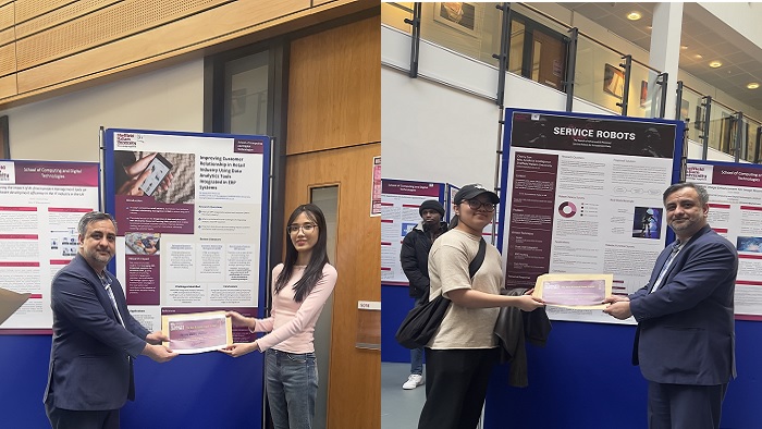 Students being congratulated by staff in front of their poster presentation