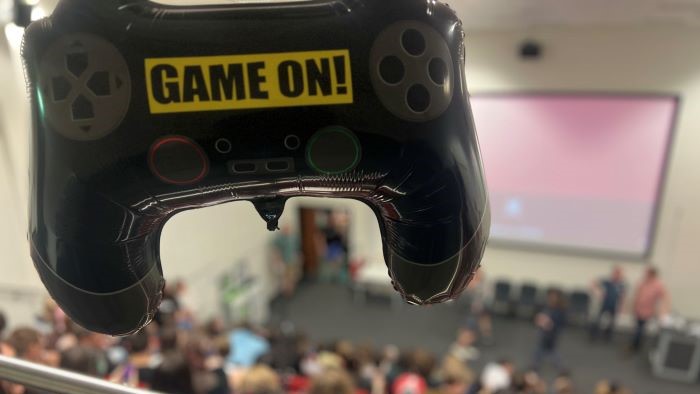 Games controller-shaped ballon in the foreground of a lecture theatre