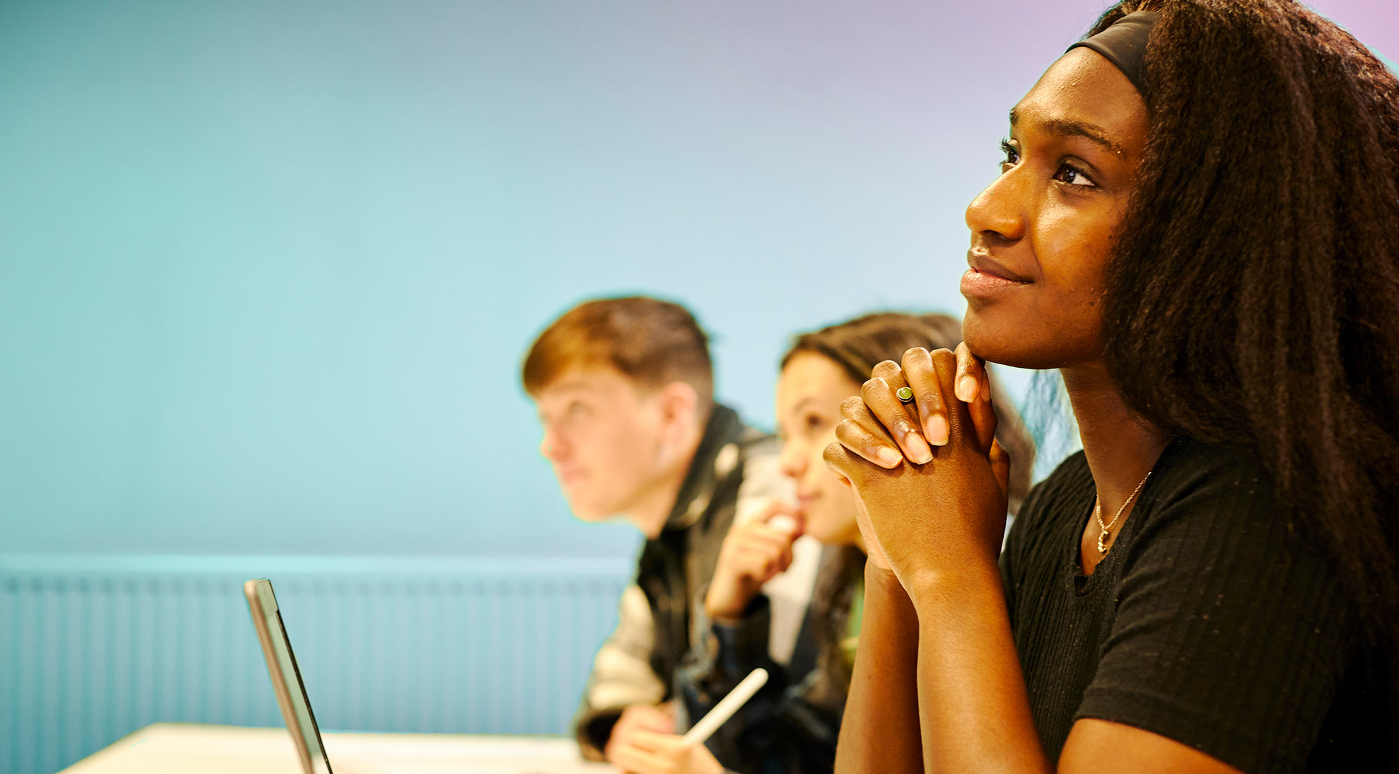 Three students sat listening to a lesson at Sheffield Business School.