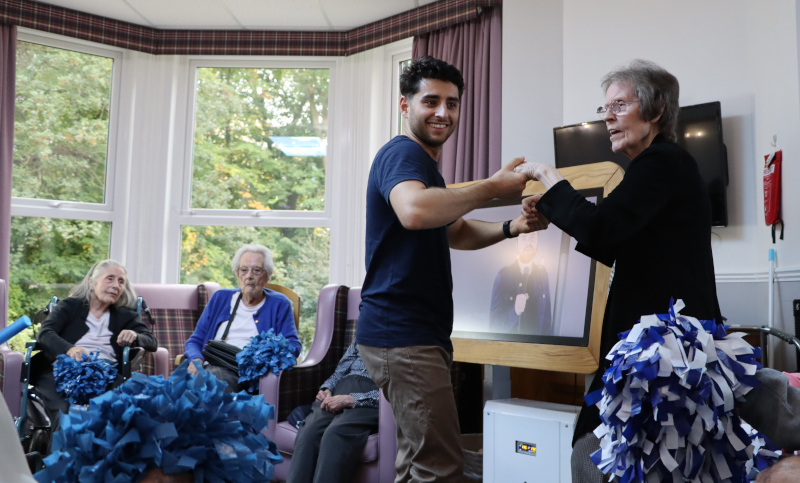 Image of Motion CEO Zeezy Qureshi dancing with Edith, care home resident. 