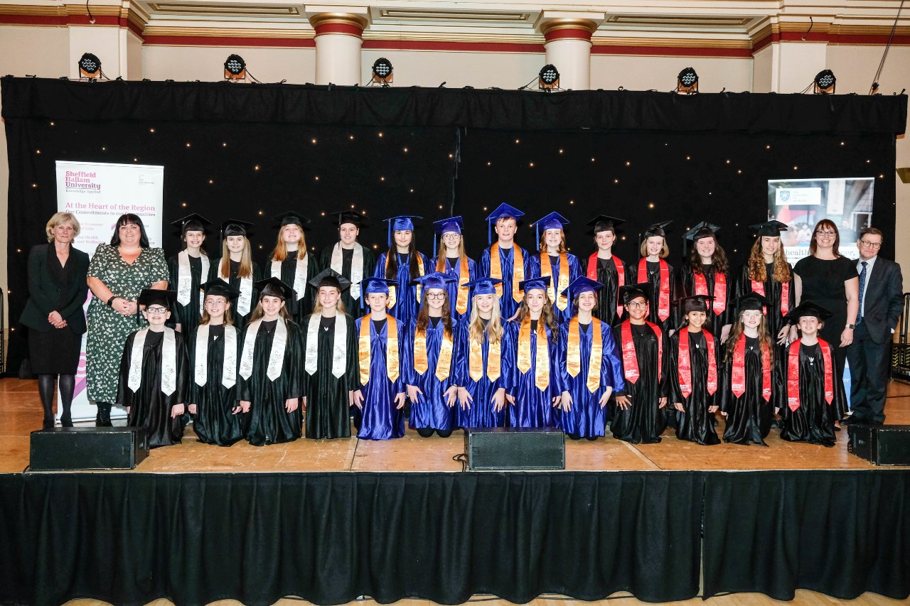 South Yorkshire Children's University pupils on stage in their graduation caps and gowns