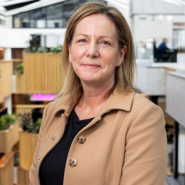 Image shows Tracey Hulme. Tracey is smiling at the camera.