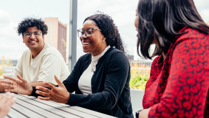 Three students at a table on the rooftop 