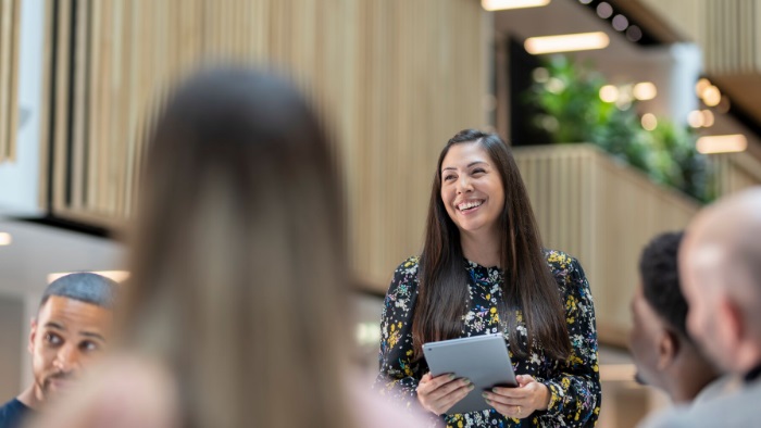 Woman smiling whilst providing support to other people