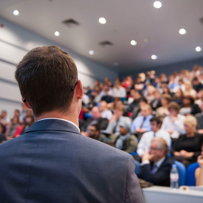 Man presenting to people sitting in a lecture theatre