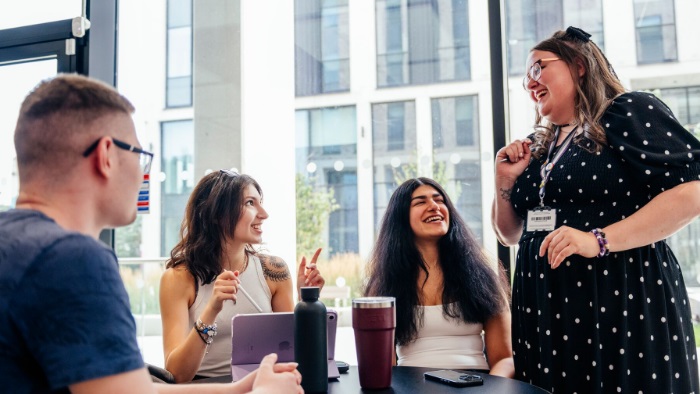 Four people laughing in an event space