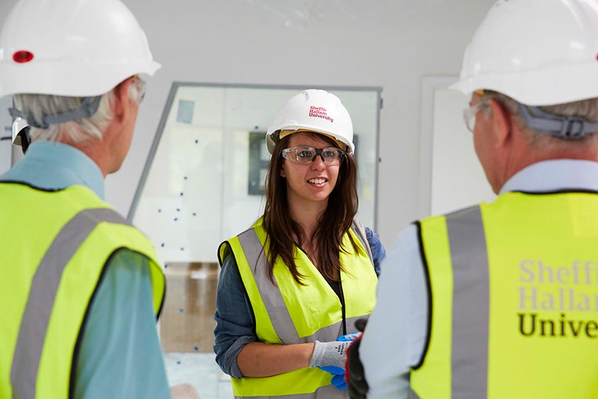 Two men and a women wearing hard hats