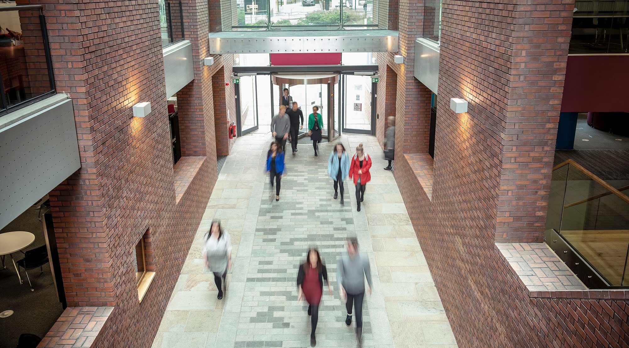 Several people seen from above walking through the central atrium of the Charles St building