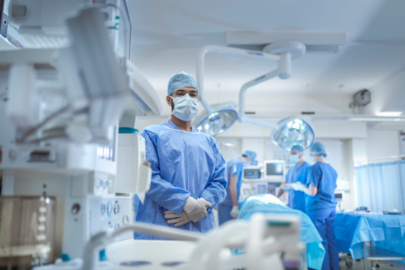 Image of a healthcare professional standing in an operating theatre wearing medical uniform