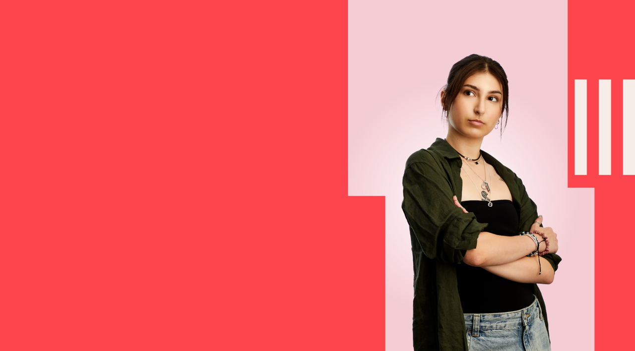 Accounting student stood confidently, wearing a black top, green shirt and jeans.