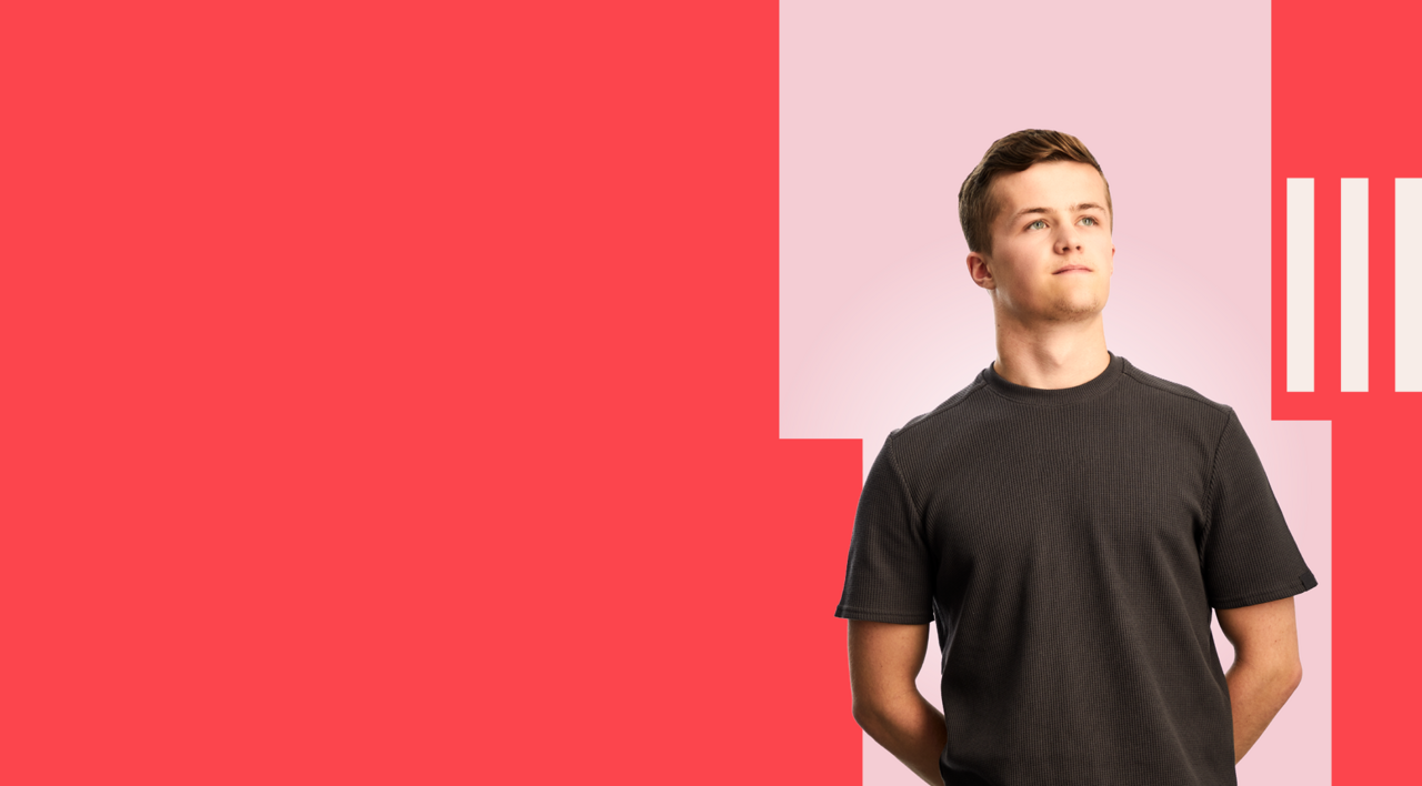 Business student stood confidently, wearing a dark grey t-shirt.