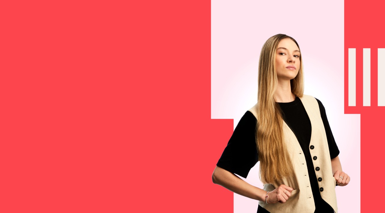 Economics student stood confidently, wearing a black t-shirt and cream waistcoat.