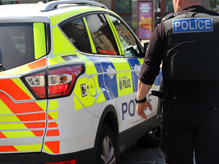 A police officer standing next to a police car