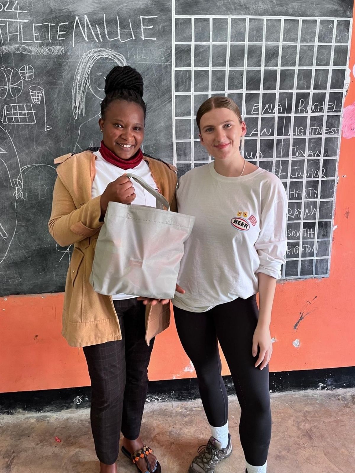 Two people standing in front of a blackboard