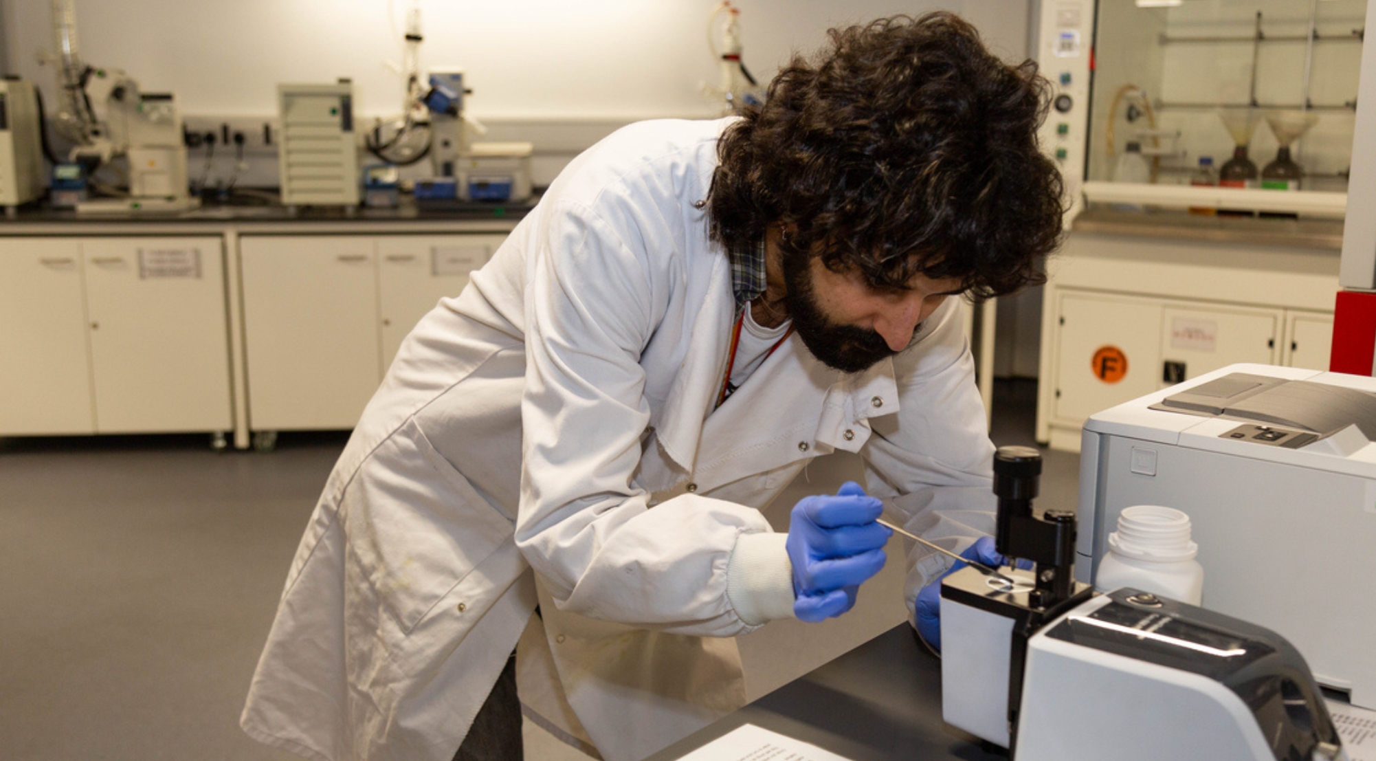 Male student looking under microscope in the laboratory