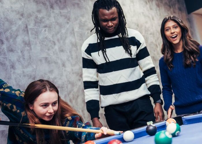 A group of students playing pool in Sheffield Hallam accomodation
