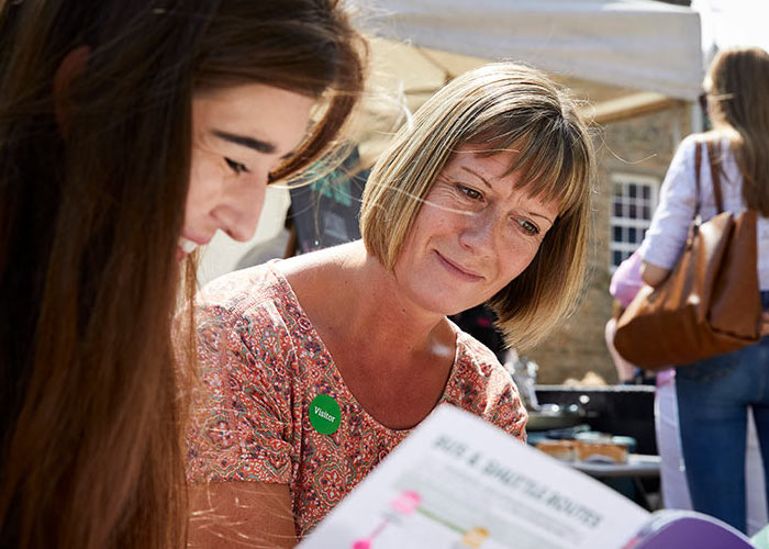A mother and daughter reading a booklet together
