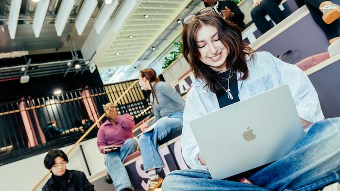 A female student using a laptop in the Sheffield Hallam business hub
