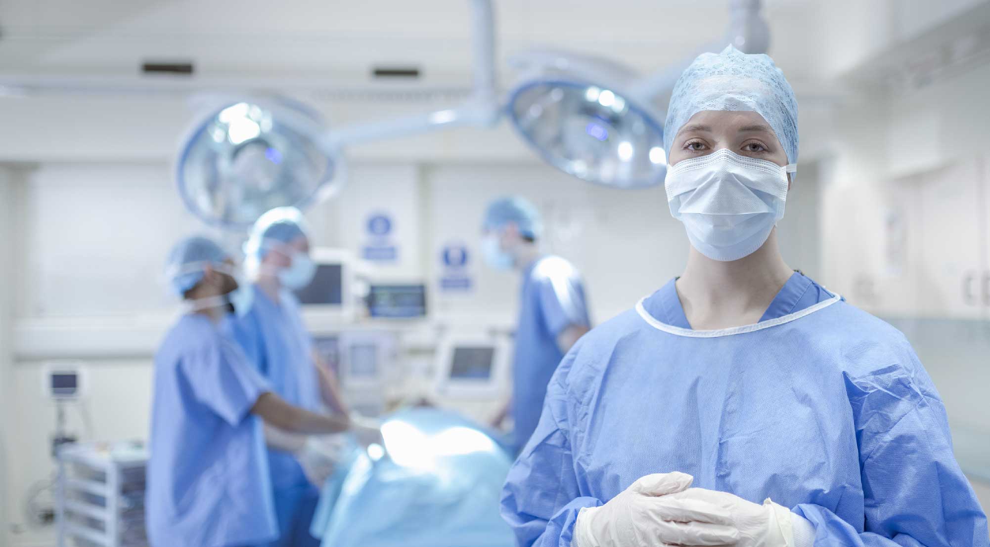 An operating department practice student wearing scrubs in an operating room