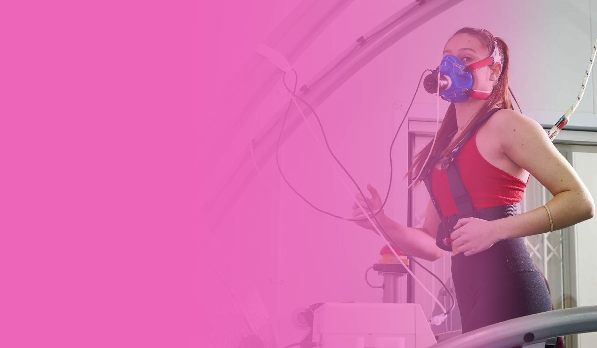 A women exercising with performance tracking equipment, against a pink gradient background