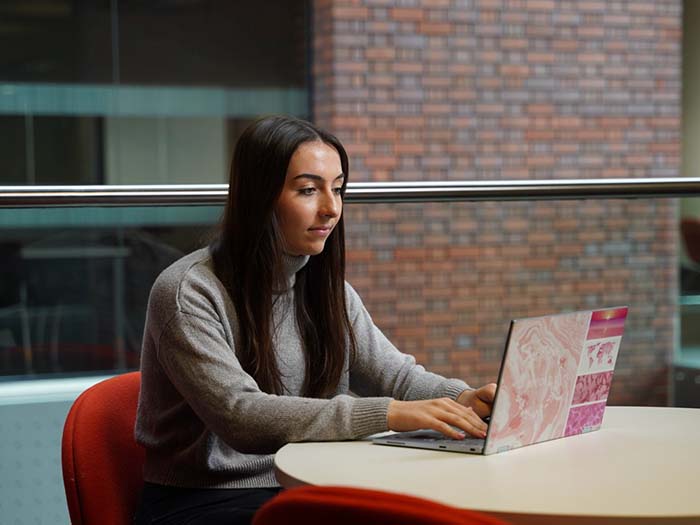 Psychology student Nicole working at a laptop