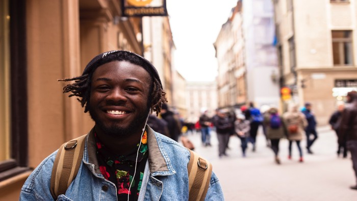 A black student standing on a busy street on his study abroad exchange