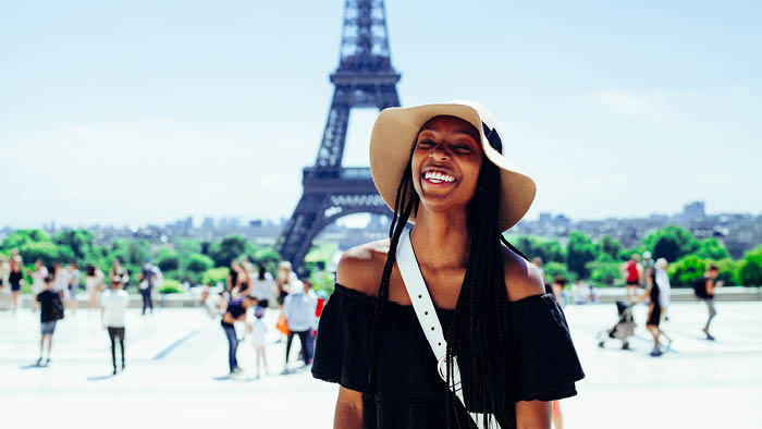 Woman smiling in front of Eiffel Tower