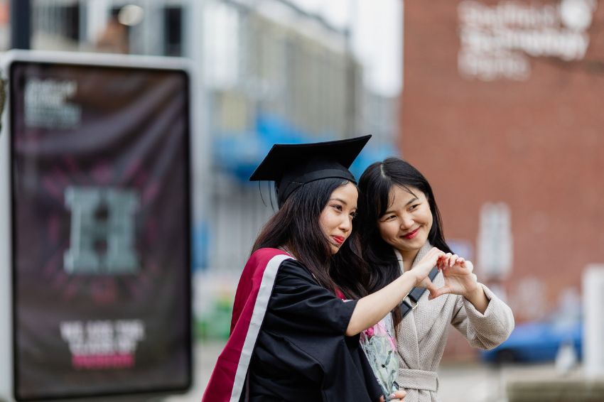 Two students posing for a selfie during graduation