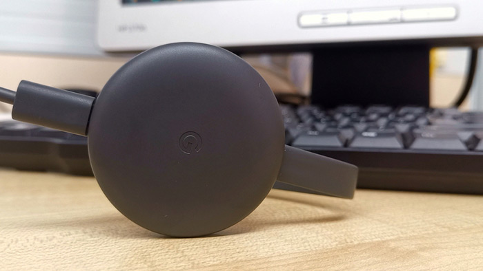 A microphone headset sat on a desk in front of a keyboard