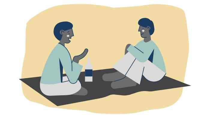 two people sat on a rug in conversation 