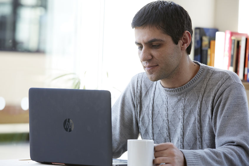 Postgraduate student using university laptop to complete work