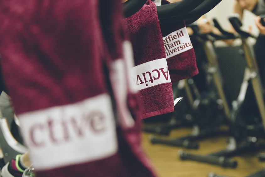 Active gym towels hanging from spinning bikes