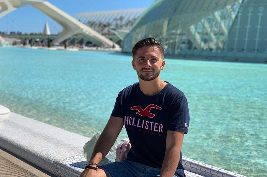 Student William Broad sitting by a pool of water in the sunshine in Valencia
