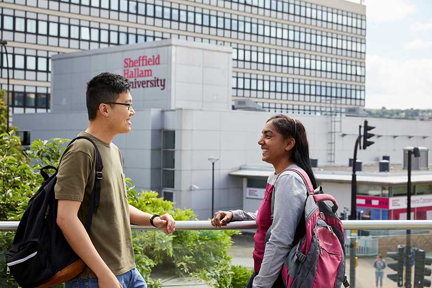 Two students talking outside a campus building