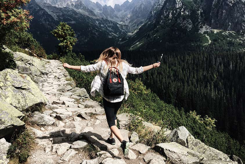 A women walking on rocks on a mountain top