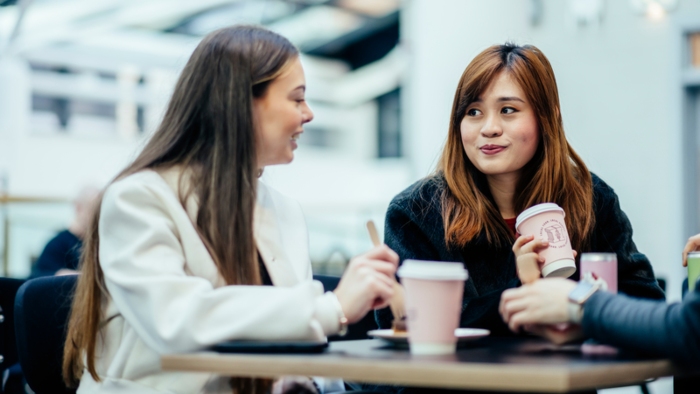 Two students sat at a table, talking