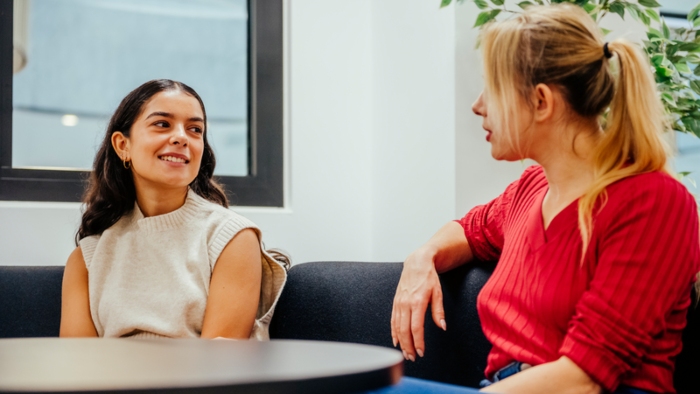 Two students sit talking 
