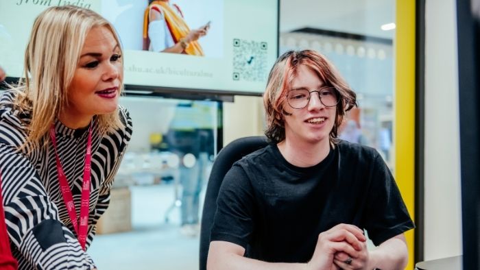 Two people looking at a computer with a bright background