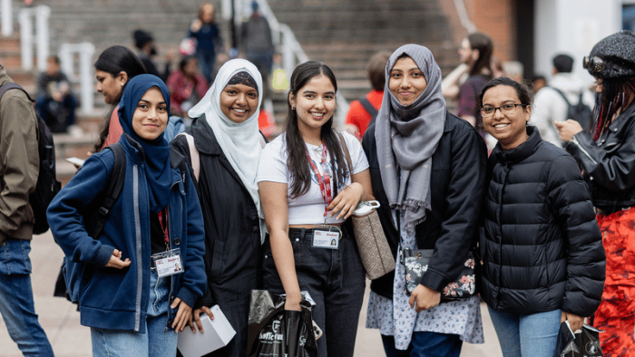 A group of young women standing together on a university campus