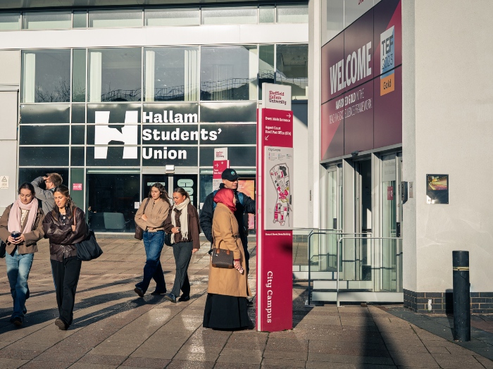 People walking by a building with a sign displaying "Hallam Students' Union".