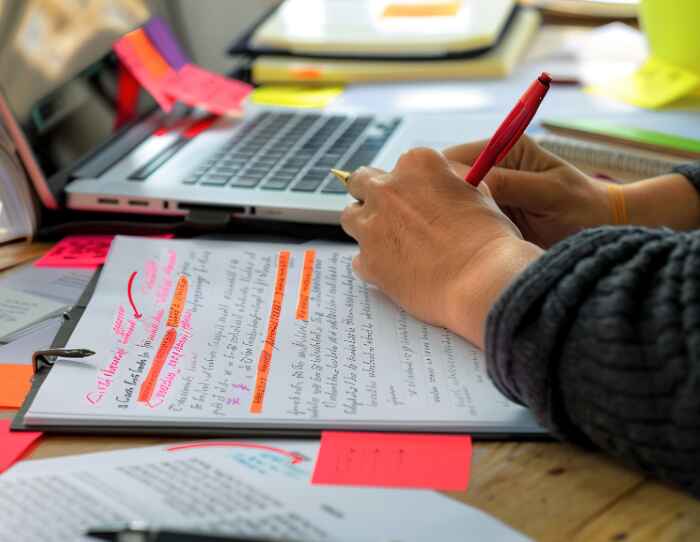 A close up of a student adding highlights and visual elements to their revision notes.