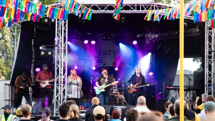 A band playing on a stage with colourful decoration