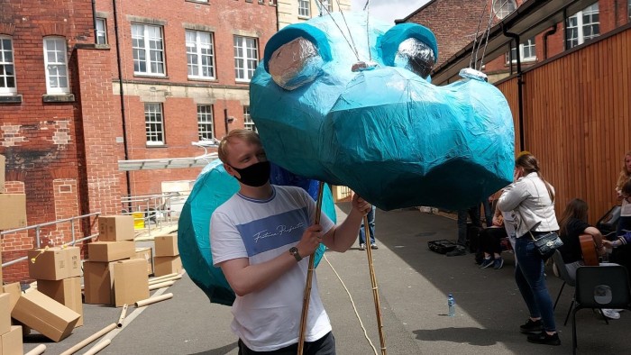 A student holding a dragon puppet that will be used as part of Awakenings