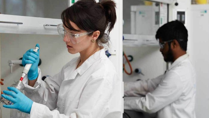 Two scientists, one male and one female, working in a lab