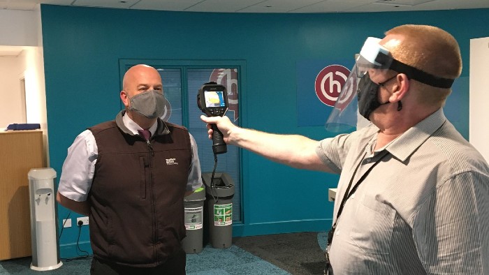 Man having his temperature checked on campus