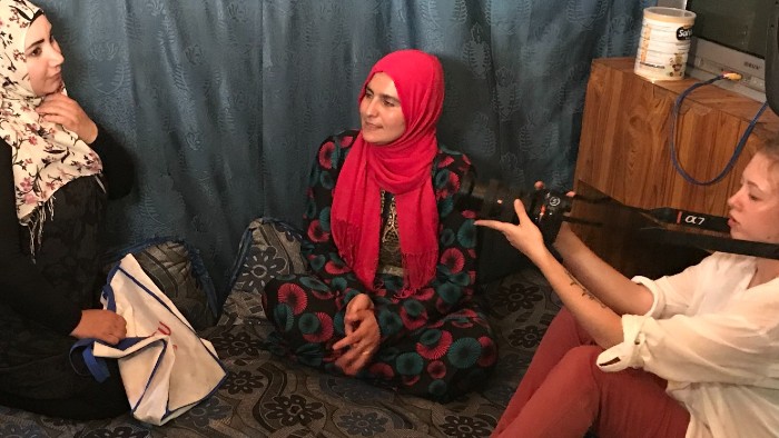 A student interviewing refugees in the Beqaa Valley.