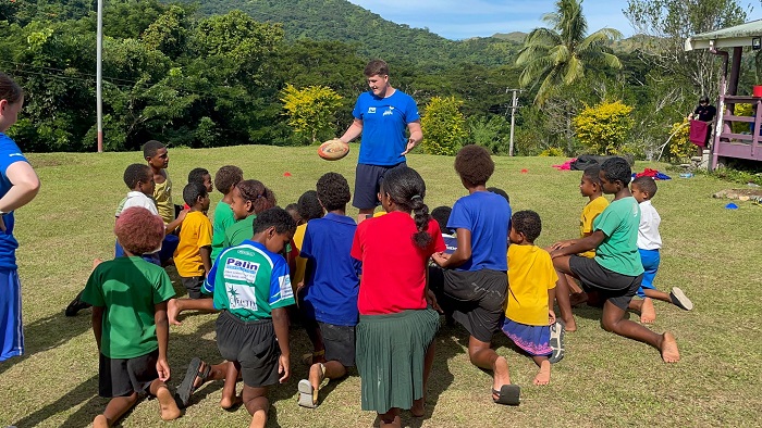 Joel and a group of children playing sport in Fiji