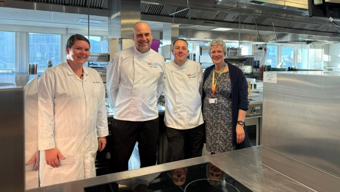Caroline Millman, standing with three food technicians, all smiling.