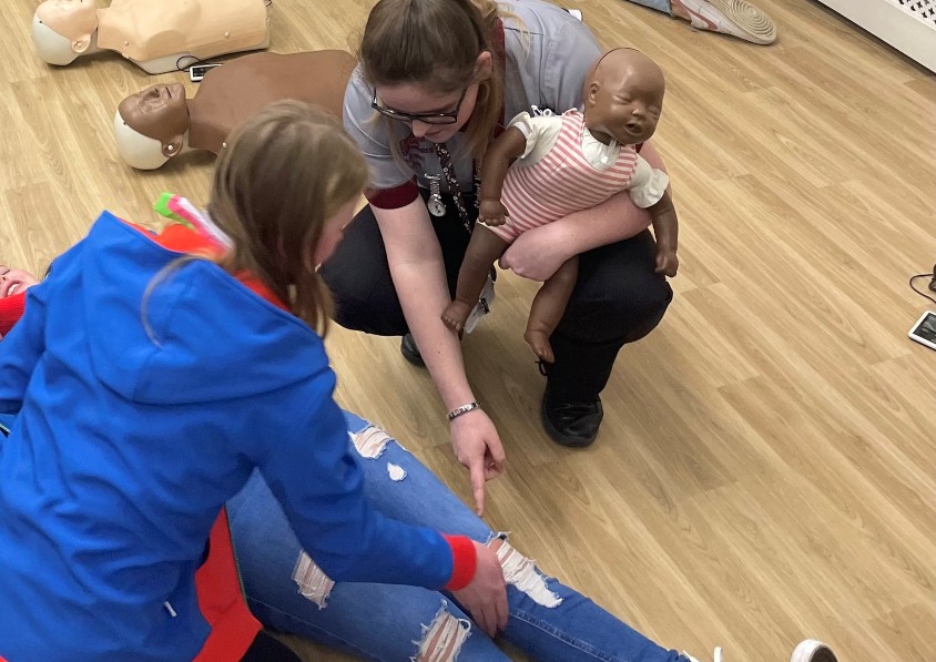 Image of a Sheffield Hallam nursing student teaching first aid to a Guides group
