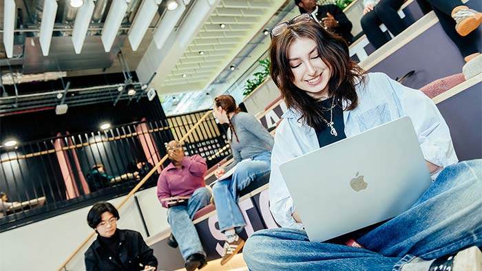 A female student working on a laptop on campus